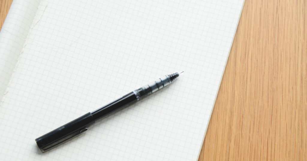 A black pen on a blank sheet of graph paper